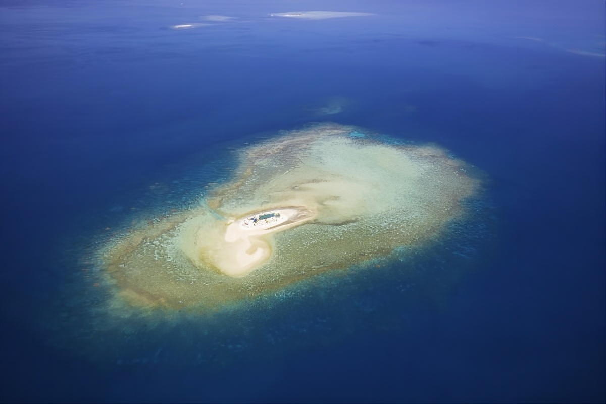 Aerial view of Savala Island surrounded by Fiji's turquoise coral reef and deep blue lagoon